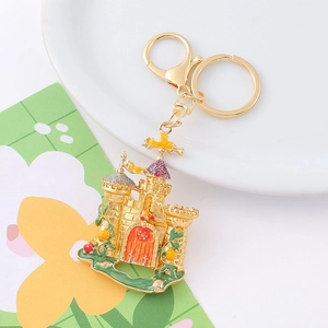 Close-up of golden castle keychain with colorful enamel coating and metal lobster clasp