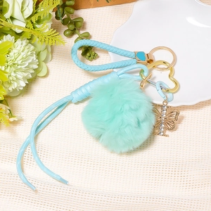 Detailed view of mint green plush ball keychain with rhinestone butterfly charm