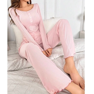 Detail of pink knit pajama set featuring lettuce edge hems and white button neckline