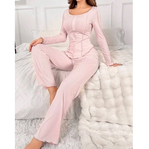 Pink long sleeve pajama set with ribbed texture and ruffle hem in bedroom setting