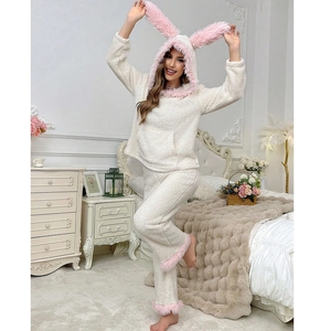 Detail view of white coral fleece pajama set featuring pink rabbit ears on the hood