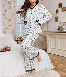 Detail of floral quilted pajama set with delicate black lace trim and bow accent