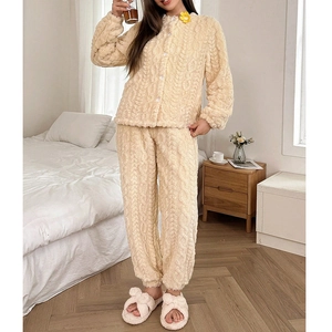 Detail of plush off-white pajama set showing thick cable knit texture and button closure