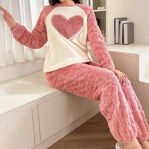 Detail view of plush coral fleece pajama set with pink heart embroidery and love you text