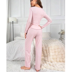 Close-up of pink long-sleeve pajama set featuring delicate lettuce trim edges and soft fabric