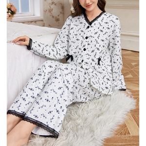 Women's floral quilted pajama set with black lace trim and bow accent in a cozy bedroom