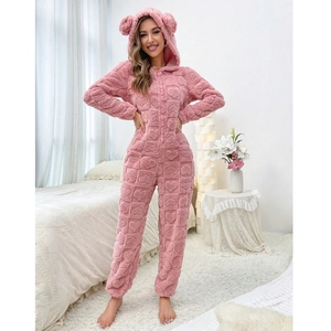 Detailed macro view of pink coral fleece onesie with embossed hearts and cute bear ears