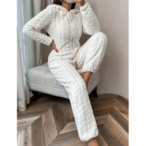 Close-up of white coral fleece onesie with embossed heart pattern and front zipper