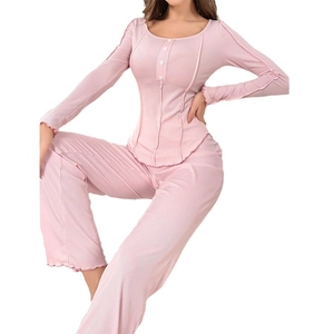 Pink ribbed pajama set featuring long sleeve buttoned top and high waisted trousers