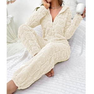 Close-up of heart-embossed coral fleece on white hooded jumpsuit with front zipper