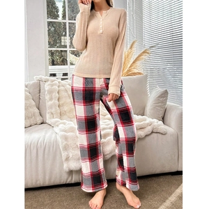 Detailed shot of ribbed knit henley top and plaid pajama pants in a cozy home setting