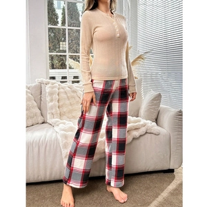 Women's pajama set featuring beige ribbed long-sleeve top and red plaid flannel trousers