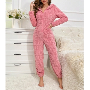 Detailed close-up of pink plush hooded onesie with embossed rabbit pattern texture