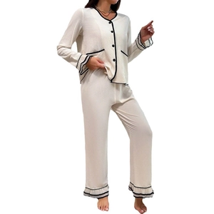 Pyjama deux pièces beige pour femme avec liseré noir contrasté et détails de volants