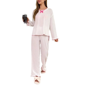 Pyjama deux pièces blanc en maille gaufrée avec nœuds roses et bords ondulés doux