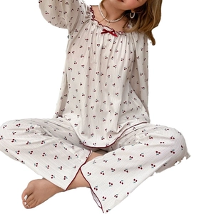 Women's pajama set featuring cherry print long-sleeved top and pants with ruffle neck