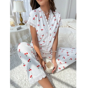 Detailed view of white cherry print pajamas with delicate lace trim on the V-neckline