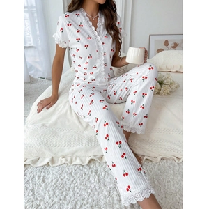 Close-up of white lace trim on cherry print pajamas with breathable waffle fabric texture