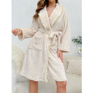 Detailed view of beige coral fleece bathrobe featuring elegant ruffled trim and waist tie