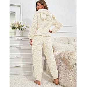 Detailed macro view of cream-white fleece pajama set with embossed heart patterns