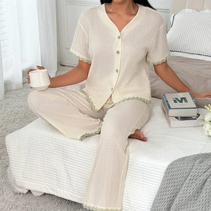 Pyjama deux pièces blanc crème pour femme avec bords ondulés verts et col en V