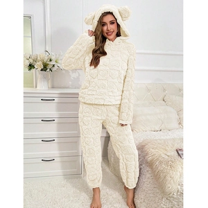 Detailed texture of cream white hooded teddy fleece pajamas with embossed heart patterns