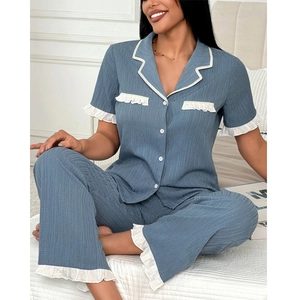 Detailed view of the ruffle trim and white buttons on the blue pajama set top