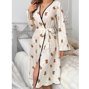 Detail of cute brown bear print on cozy cream long-sleeved bathrobe with waist tie