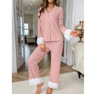 Détail du pyjama rose montrant les poignets à volants blancs et la texture côtelée douce