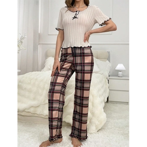 Close-up of ribbed knit pajamas featuring delicate lettuce edge trim and plaid pants