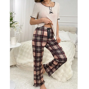 Women's pajama set featuring beige ribbed top with black bow and pink checkered pants
