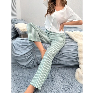 Close-up of white V-neck pajama top with light blue buttons and striped pants texture
