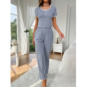 Grey two-piece pajama set with white lace trim and heart buttons in a bright bedroom