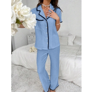 Detail of light blue striped pajama set featuring black wavy trim and button-down front