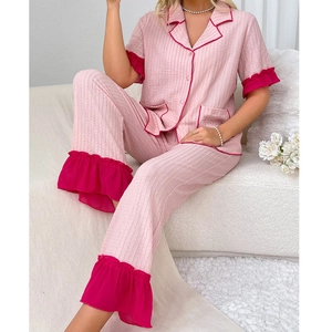 Detail of pink seersucker pajamas with bright fuchsia ruffled edges and chest pockets