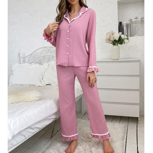 Dettaglio pigiama rosa in maglia a costine con bordi smerlati bianchi
