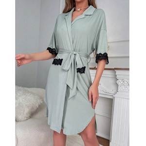 Vestaglia in maglia verde salvia con pizzo nero e cintura in un ambiente moderno