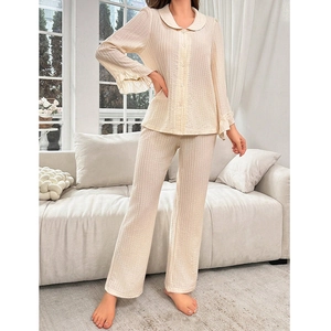 Detail of ruffle cuffs and vertical ribbed texture on beige long-sleeve pajama set