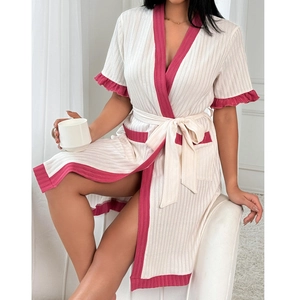 Detail of short sleeves with ruffle cuffs and contrast trim on white knit bathrobe