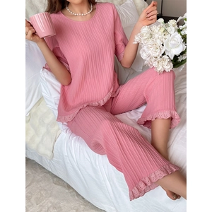 Detail of pink pleated loungewear set with delicate eyelet lace trim on the hem
