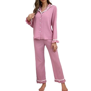 Set pigiama a righe rosa con maniche lunghe, volant bianchi e pantaloni coordinati su sfondo bianco