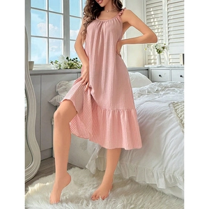 Pink ruffle-trim sleeveless nightdress with vertical striped texture in a modern bedroom