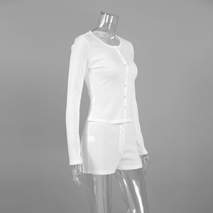 Detail of white knit pajamas with vertical stripes, lace trim and button closure