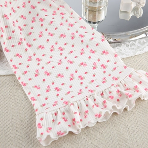 Detail of floral print knit robe showing ribbed texture and delicate ruffle hem edges