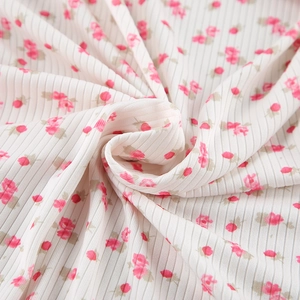 Macro shot of soft cream ribbed knit fabric with pink floral print and vertical texture