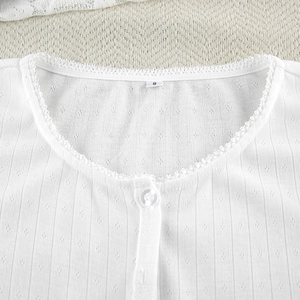 Close-up of white waffle knit pajama top with lace trim and translucent buttons