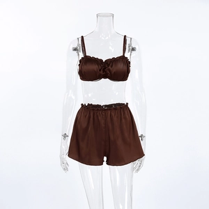 Detail of satin camisole set with ruffled edges in dark coffee brown fabric texture
