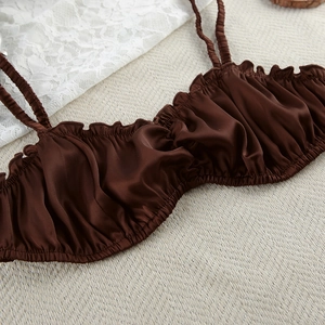 Detail of silk satin camisole with ruffled neckline and elegant chocolate brown texture