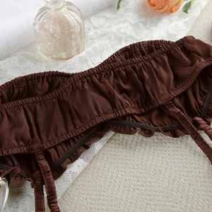 Close-up of brown satin lingerie accessories with ruffle edges and elastic silk details