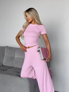 Detalle de conjunto rosa de seda de leche con camiseta corta y pantalón ancho